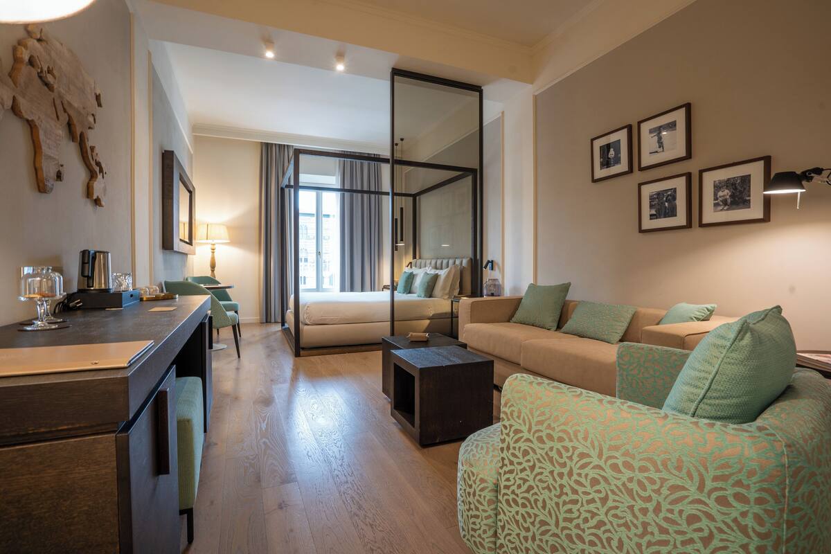 A modern living room with a sofa, a coffee table, and a dining area with a table and chairs.