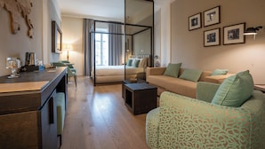 A modern living room with a sofa, a coffee table, and a dining area with a table and chairs. - Anna Teresa Luxury (Pisa)