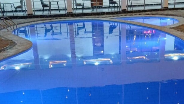 Una piscina con borde de azulejos y decoración de piedra.