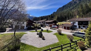 A village with traditional chalet-style houses, a cobblestone courtyard, and a mountainous backdrop. - Fewo Sonnenglück - dreamlike 2-room apartment for 1-2 persons with corner balcony (Schönau am Königssee)