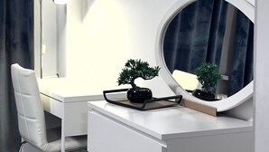 A modern, minimalist room with a white desk, chair, and dresser, a round mirror, and a small bonsai tree. - Apartment 'In Fuldatal - Kassel' with Private Garden and Wi-Fi (Fuldatal)