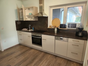 Una cocina moderna con horno empotrado, lavavajillas y ventana con vistas.