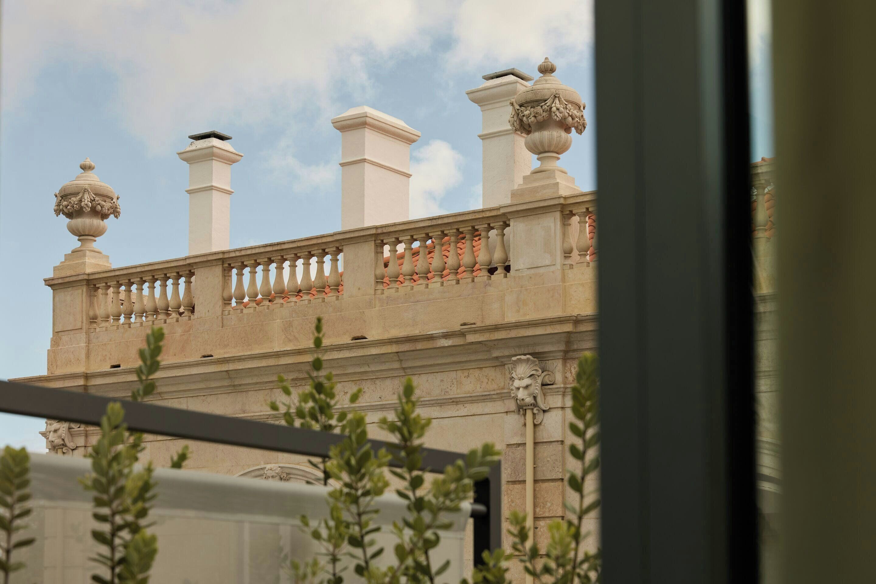 Un bâtiment doté d’un balcon, d’une balustrade et d’un vase décoratif.