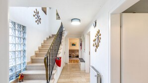 A staircase leading to a dining area with a view of a kitchen and a dining table.