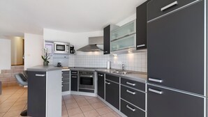 A modern kitchen with a microwave, oven, and stainless steel cabinets. - Apartment 'Seeside' with Lake View, Balcony and Wi-Fi (Uhldingen-Mühlhofen)