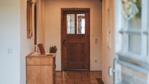 A hallway with a wooden door, a wooden cabinet, and a metal door frame. - Holiday Home 'Kaiser' with Mountain View, Private Terrace and Wi-Fi (Aßling)