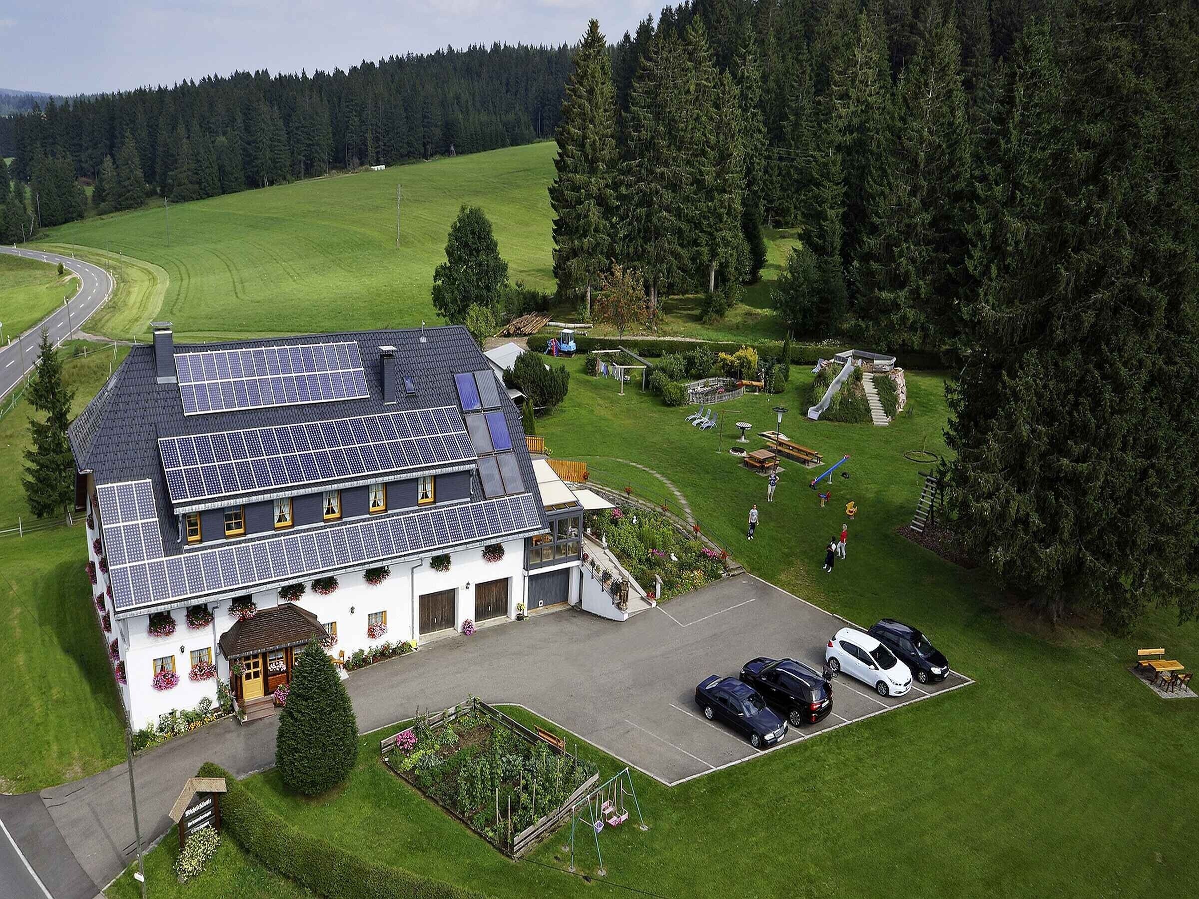 Un hôtel doté d’un grand parking, de panneaux solaires sur le toit et d’un jardin avec une aire de jeux.