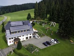 A two-story building with solar panels, a parking area, and a well-maintained lawn.