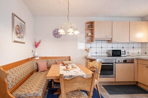 Une cuisine chaleureuse avec des meubles en bois, un four à micro-ondes et un four encastré.
