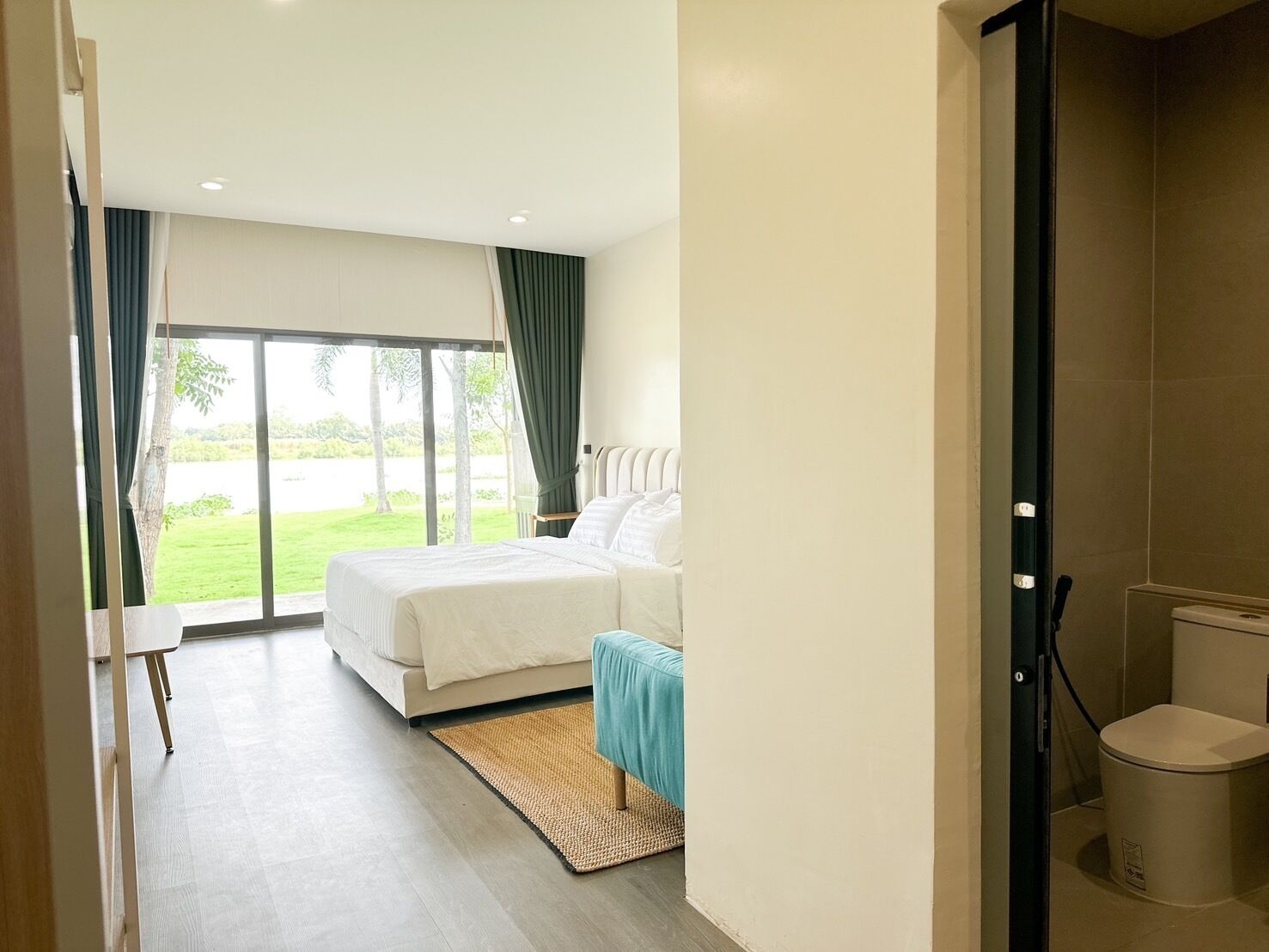 Een hotelkamer met een bed, een kleintje tafeltje en uitzicht op de omgeving.