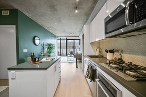 Une cuisine moderne dotée d’un îlot central, d’un four à micro-ondes et d’une cuisinière.