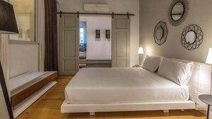 A bedroom with a bed, bedside tables, a lamp, and decorative mirrors on the wall. - ISIDORO E PERLA FLORENCE SUITES (Firenze)