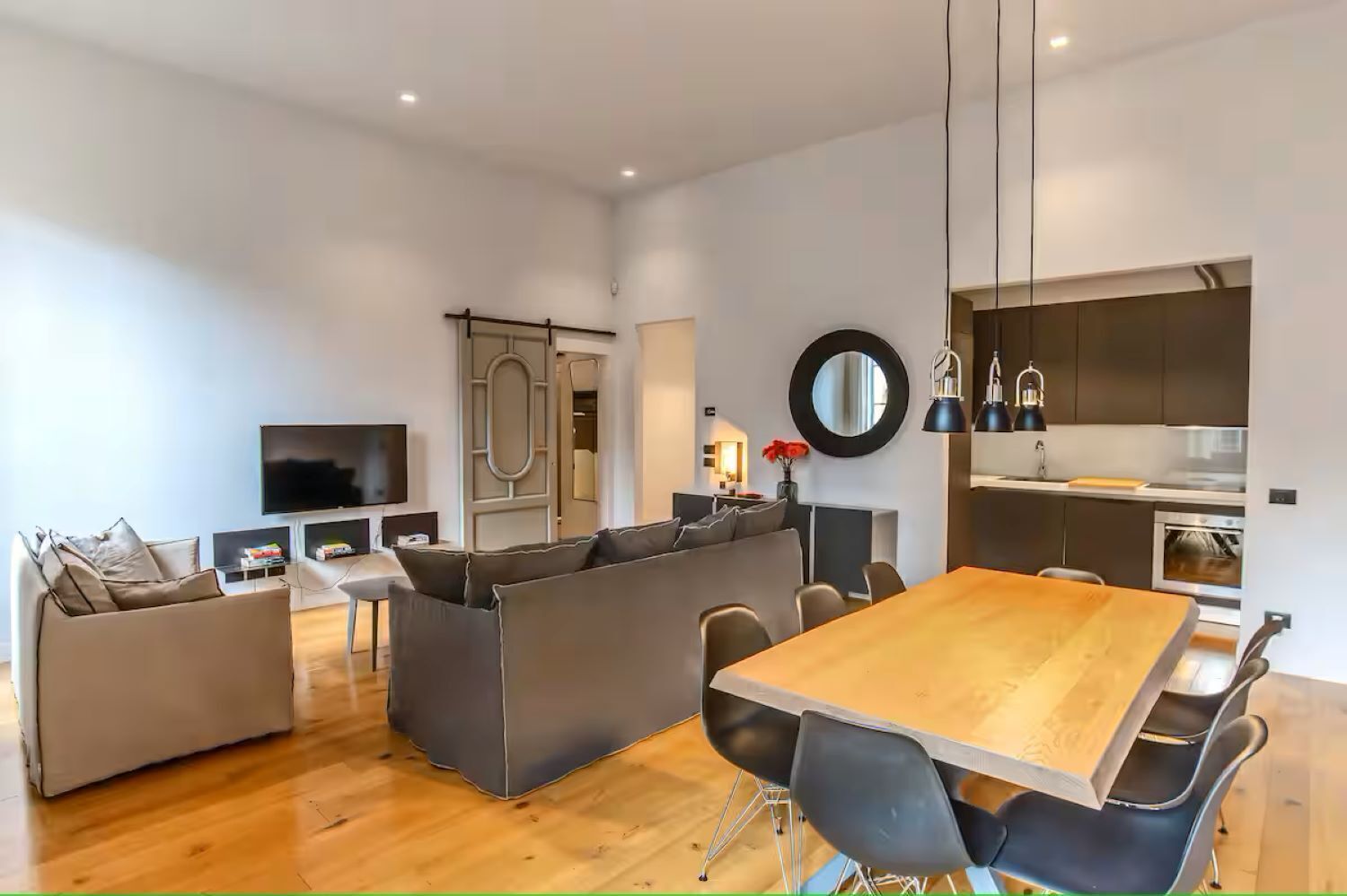 Un espacio habitable moderno con comedor, cocina y equipo de entretenimiento.