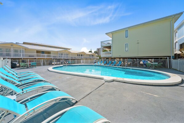 Relax by the pool surrounded by comfortable lounge chairs and a clear view of the surrounding buildings.