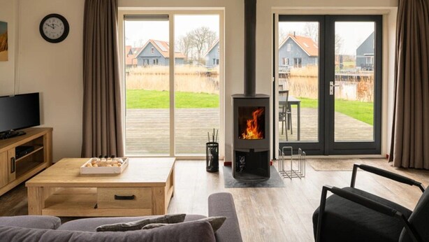 A living room with a fireplace, a television, and a sofa. - Holiday home in Langelille for family (Langelille)