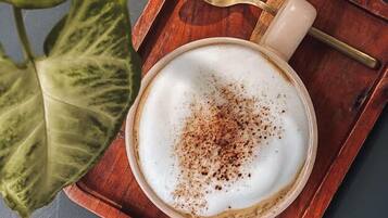 A cup of coffee with a spoon on a wooden tray.