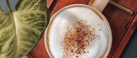 Una taza de café con una cuchara sobre una bandeja de madera.