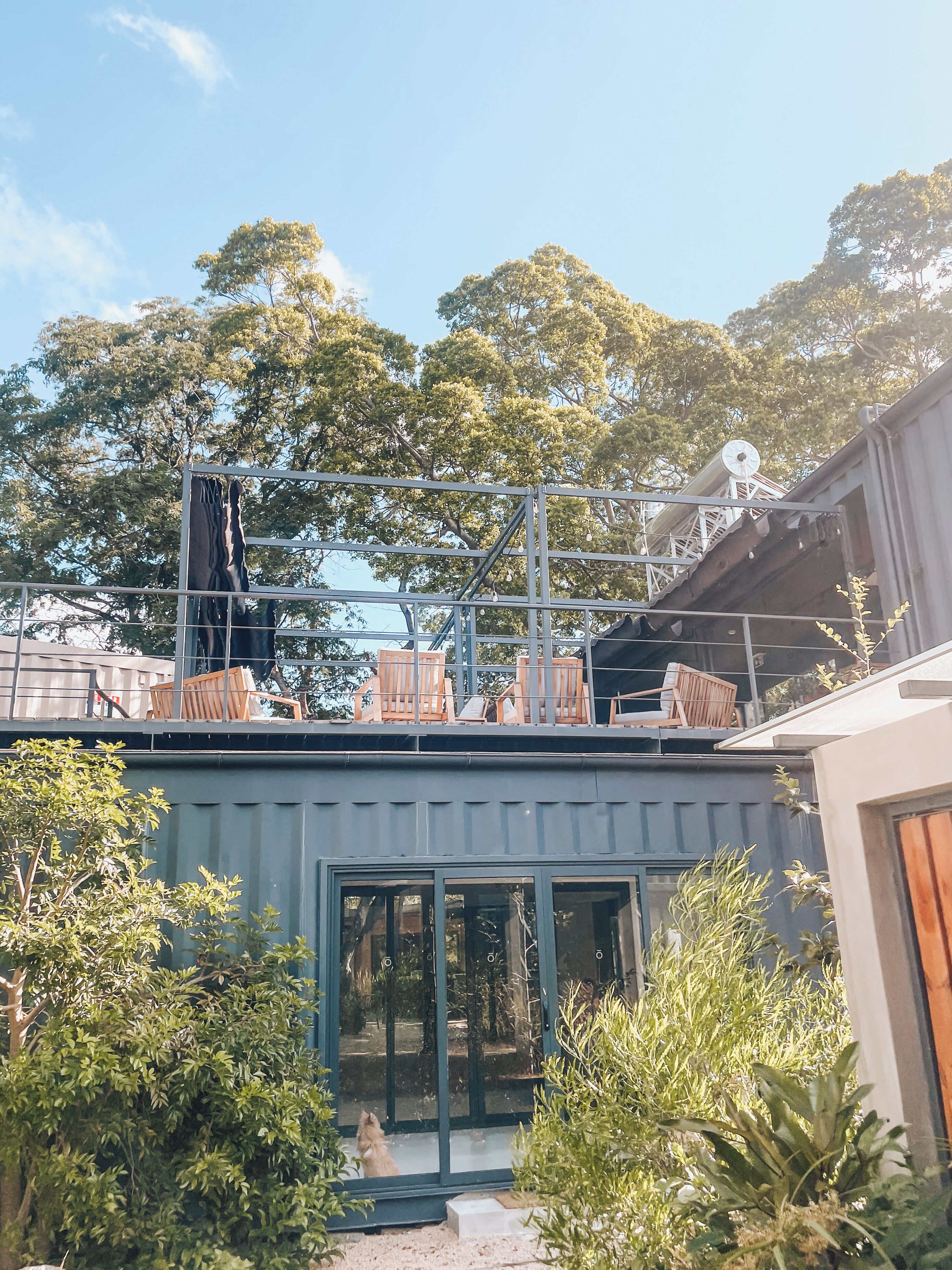 A building with a balcony, a satellite dish, and a view of trees.