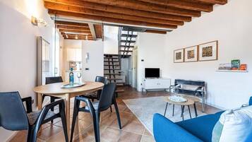 Departamento Deluxe, patio, vista al lago | Área de sala de estar | Televisión de 20 pulgadas con canales digitales