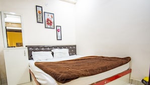 Une chambre avec un lit, une armoire et un petit coin cuisine.