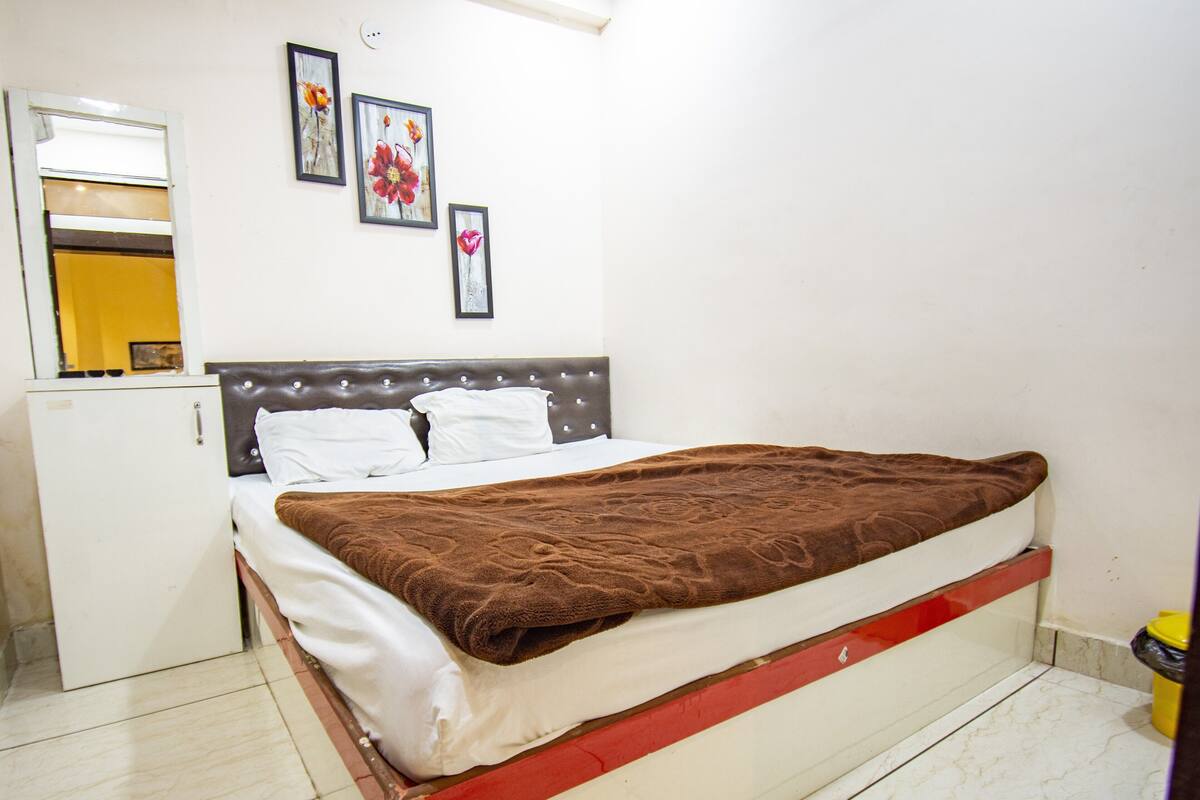 A bedroom with a bed, a wardrobe, and a small kitchenette.