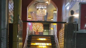 A staircase with illuminated steps leading to a room with a chandelier. - Prince Park Vellore (Vellore)