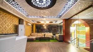 A modern interior with a sofa, coffee table, and decorative ceiling. - Prince Park Vellore (Vellore)