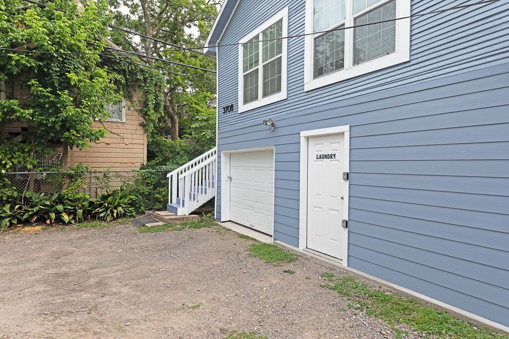 A two-story building with a blue exterior and a white garage door labeled "laundry."