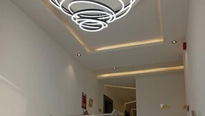 Una escalera moderna con barandilla de metal y un aplique circular arriba.