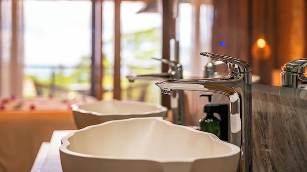 A bathroom with two white ceramic sinks and a chrome faucet. - Gardens Hill Resort & Spa Seychelles (Beau Vallon)