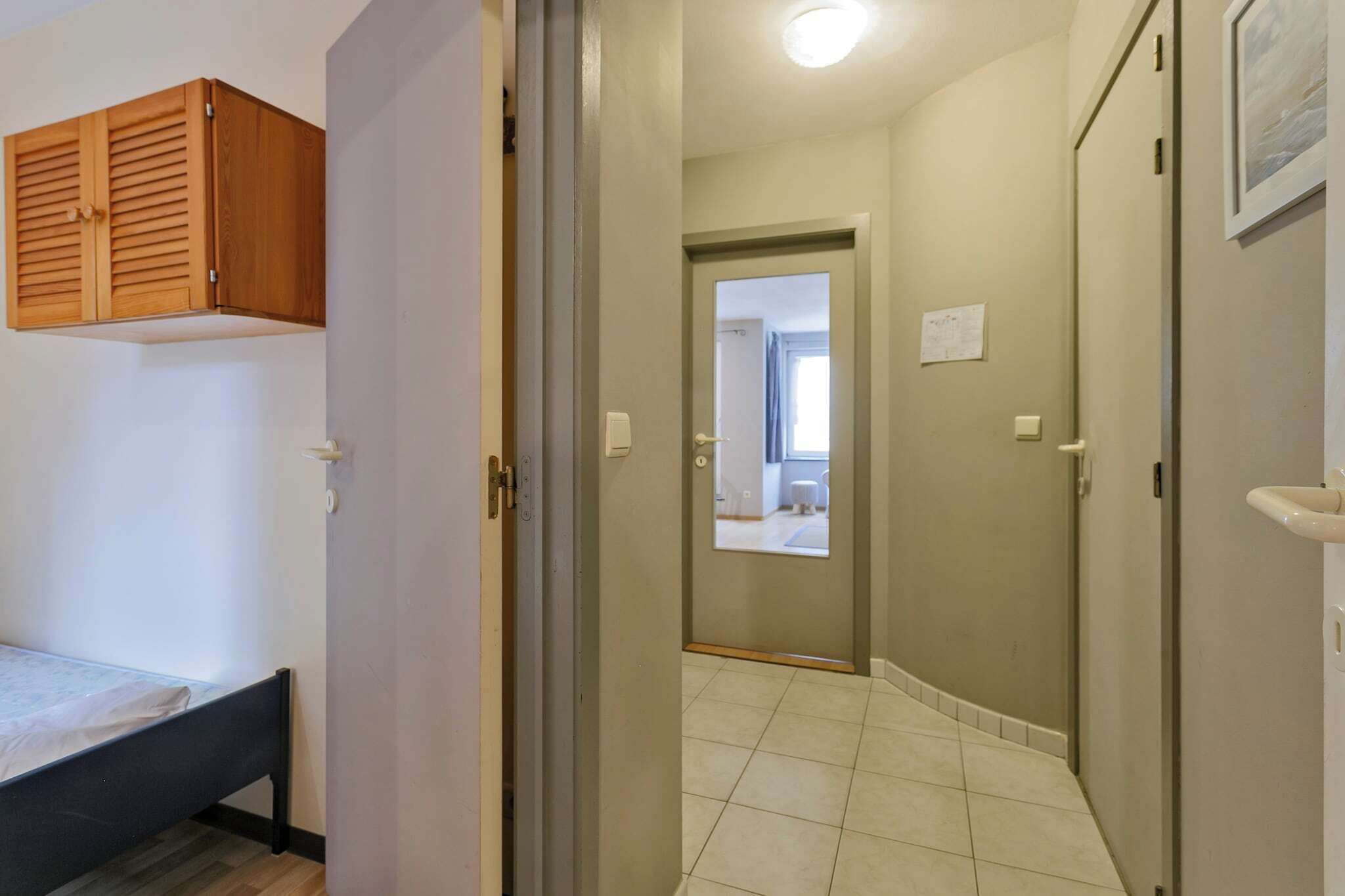 Una habitación con una cama, un armario de madera y una puerta que da a un baño.