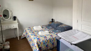 Ein Schlafzimmer mit einem Bett, einem Nachttisch, einem Spiegel und einem kleinen Beistelltisch.
