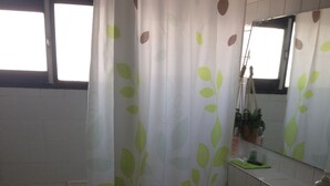 Un baño con lavadora, lavabo y espejo.