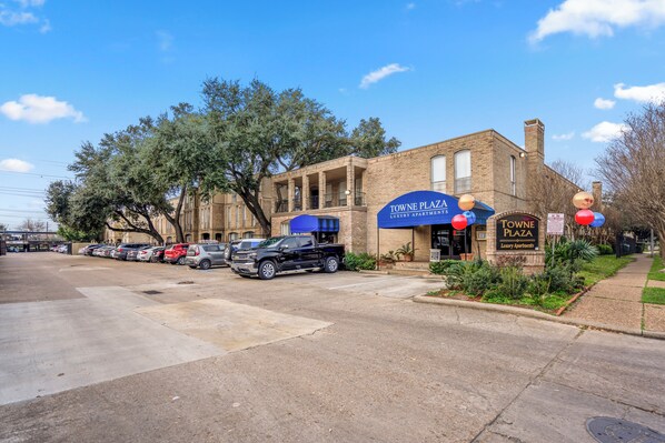 Un edificio con toldo azul que dice "Towne Plaza Luxury Apartments".