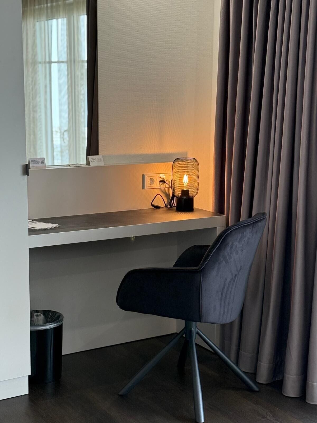 Ein moderner Arbeitsplatz mit Schreibtisch, Stuhl und Schreibtischlampe.