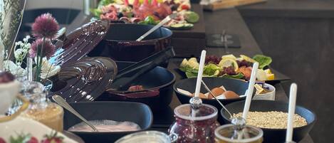A buffet table with various food items and condiments.