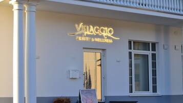 Un edificio con un cartello che riporta la scritta "Villaggio Beauty & Wellness".