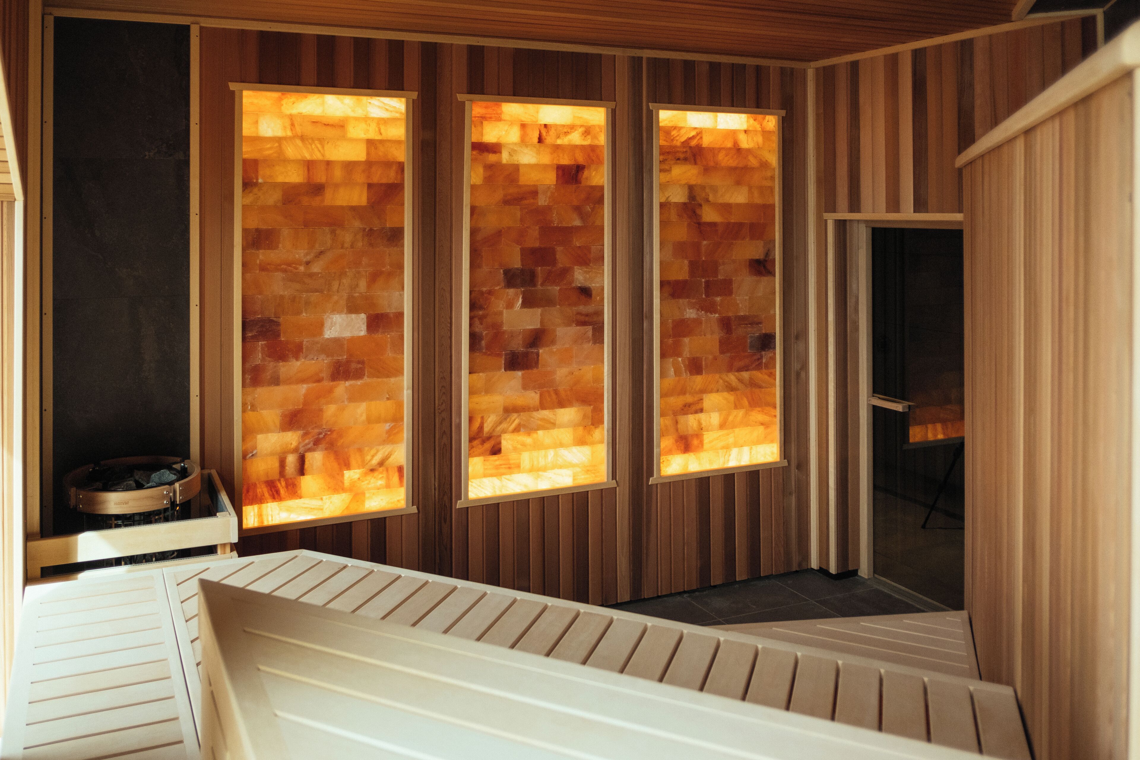 A sauna room with wooden walls and a bench.