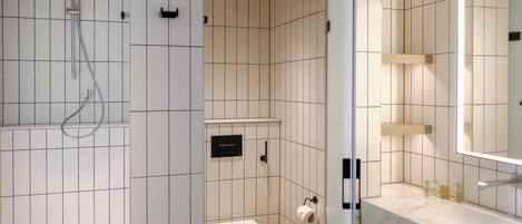 Un baño moderno con ducha, inodoro y tocador con espejo.