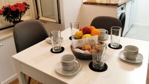 A dining table set with plates, bowls, glasses, and a fruit basket. - Apartment Mama H (Dubrovnik)