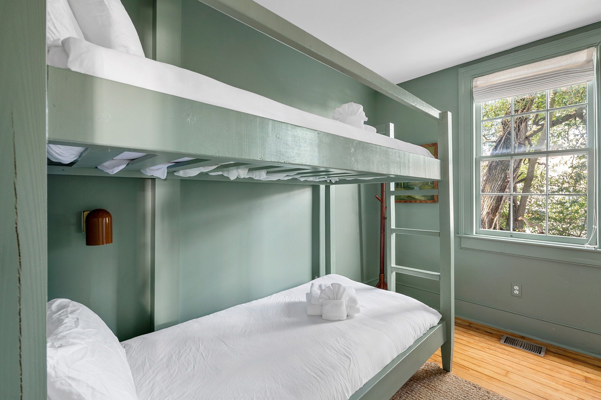 A bunk bed room with a window and a ladder.