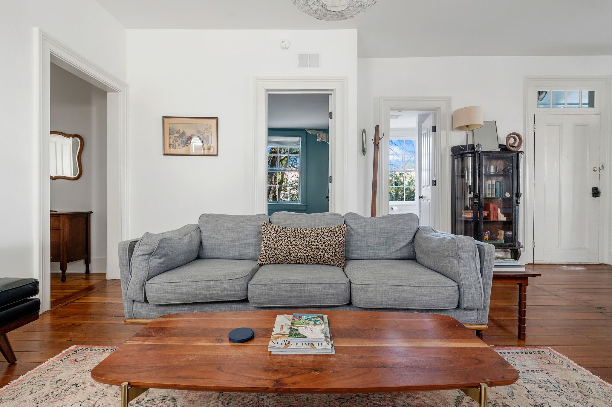 A living room with a grey sofa, a wooden coffee table, and a bookshelf.