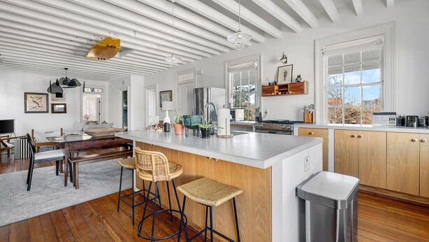 A spacious kitchen with a large island, wooden cabinets, and a view of the outdoors. - Oak Loft Downtown, Steps to King St Bars & Restaurants (Charleston)