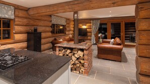 A log cabin interior with a kitchen area, a seating area with a fireplace, and a dining area. - Luxury Secluded Log Cabin with a Hot Tub - Sleeps 8 - Dog Friendly - River View (Longtown)