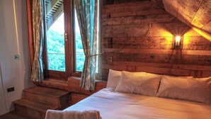 A wooden cabin bedroom with a bed, two pillows, and a stack of towels. - Luxury Secluded Log Cabin with a Hot Tub - Sleeps 8 - Dog Friendly - River View (Longtown)