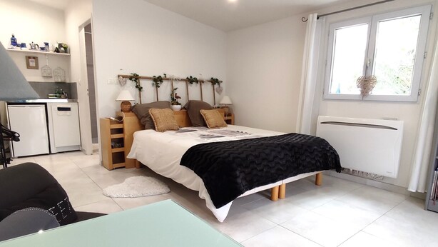 Une chambre à coucher moderne avec un lit, des tables de chevet, un bureau et une fenêtre.