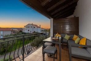 Enjoy the view from this balcony with a sofa, chair, and table.