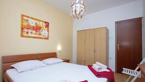 Ein Schlafzimmer mit einem Bett, einem Holzschrank und einer Tür.