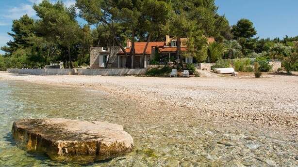 A beach house with a clear view of the sea, surrounded by trees and a rocky shoreline. - NEW! Exclusive Beachfront Villa with Pool for 8 at Island Brač (Mirca)