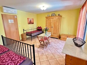 Cozy retreat with a bed, table, and chairs, plus a door and window for natural views.